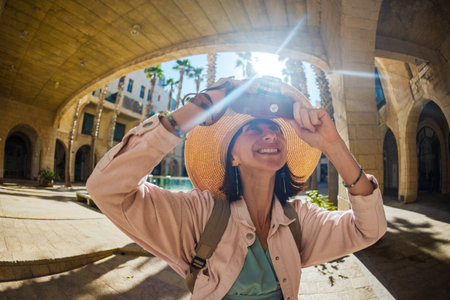 Woman photographer with camera taking pictures outdoors. Girl in dress with camera outdoors. excursions and city walk. lifestyle, travel and people concept.の写真素材
