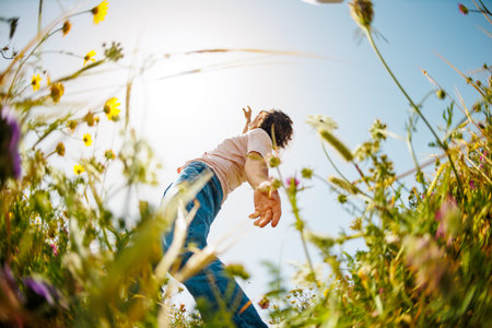 young and cheerful guy dances among the flowers. Man dancing in nature. Summer mood. Happy young guy...