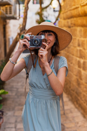 Female photographer with camera shooting in the city. Young female photographer aiming the lens and...