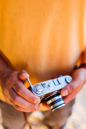 The man holds the camera and adjusts it. man with a camera. the photographer adjusts the camera.