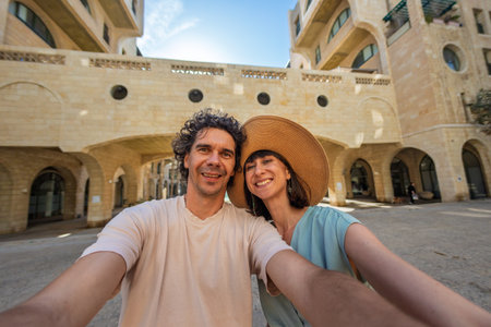 Beautiful young couple in love standing on the city street, taking selfie and enjoying walk. love and relationship.の写真素材
