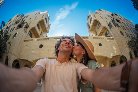 Beautiful young couple in love standing on the city street, taking selfie and kissing. love and relationship.の写真素材