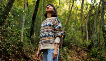 girl with a backpack enjoys a walk in the forest. trekking in the forest. a young girl in a stylish...