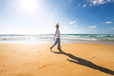 Woman on the beach. Happy young woman in a white shirt enjoying her vacation on the beach. Free lifestyle concept.の写真素材