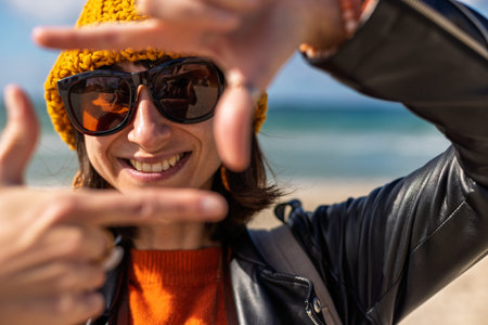 girl smiles. portrait of a cheerful girl on the beach on a sunny day. stylish woman in a hat and...