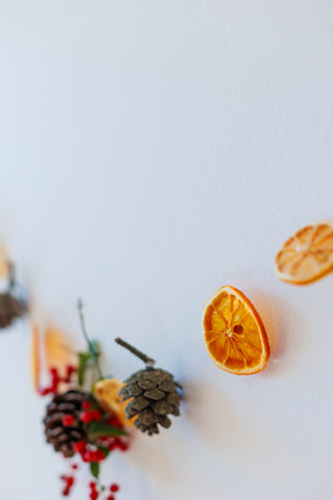 Christmas composition. Christmas, winter, new year concept. Garland of berries, dry orange slices and fir branches on a white background. copy spaceの写真素材