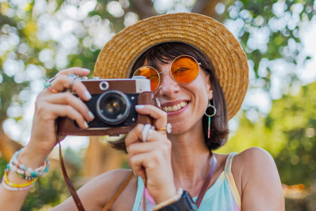 Close-up portrait of stylish young tourist pictures taking on camera on the street. stylish girl...