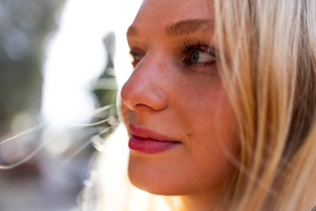 A young blonde smiles happily while standing in the city. Portrait of a girl.の写真素材