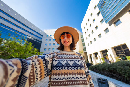 girl takes a selfie. a woman in a fashionable style takes a photo of herself on a smartphone while...
