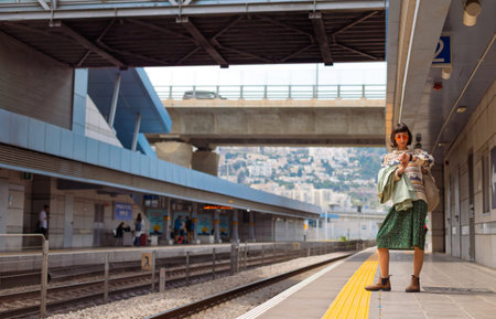 girl looking at watch and waiting for train. girl standing at train station waiting for train....