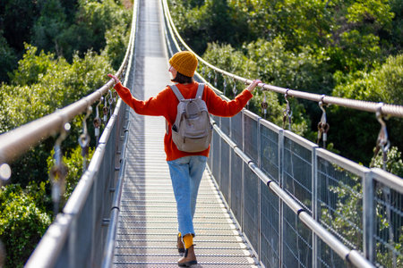 attractive happy young girl in stylish clothes with a backpack on a hike. a girl with a backpack...