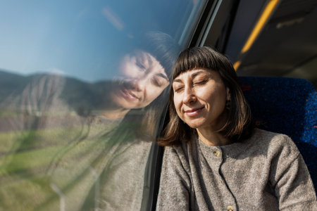 A train journey. A young woman rides on a train, admiring the beautiful scenery and gazing...