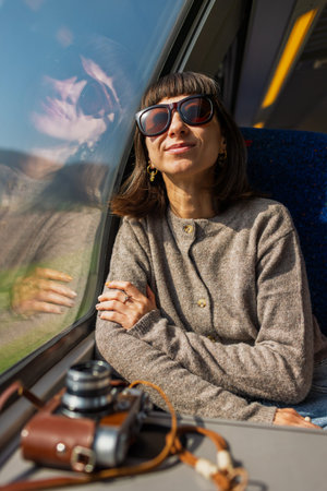 A train ride. A young woman is riding on a train, admiring the beautiful scenery and looking out the...