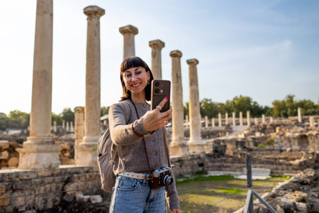 A girl takes pictures with her phone. A tourist with a backpack photographs landmarks for her blog...