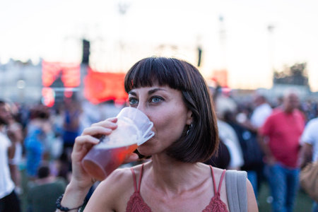 girl enjoying moment at music festival and drinking beer. Young woman drinking beer and having fun at music festival. vacation concept.