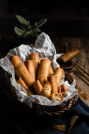 Traditional Asian Fried Spring Rolls in Bamboo Basket with Dipping Sauceの写真素材