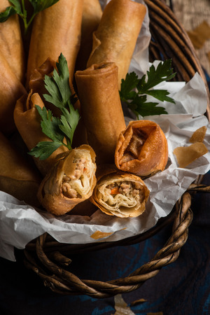 Traditional Asian Fried Spring Rolls in Bamboo Basket with Dipping Sauceの写真素材