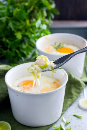 Breakfast with eggs baked with onion in porridge bowls, selective focusの写真素材
