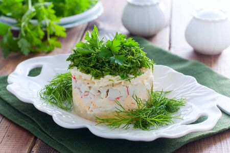 Salad with crab sticks and cheese on a white plate, horizontalの写真素材