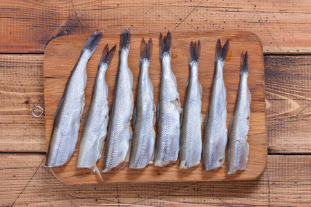 Step-by-step preparation of fried smelt in a pan, step 3 - cutting of raw smelt fish, top view, selective focusの写真素材