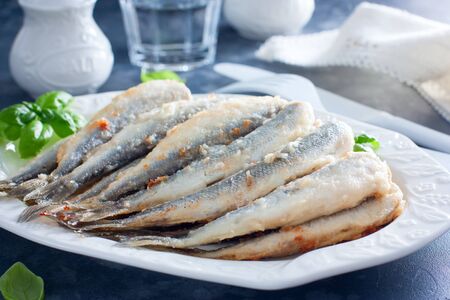 Fried smelt on a white dish, selective focusの写真素材