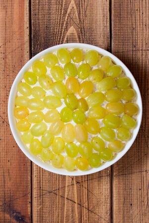 Step-by-step preparation of Tiffany puff salad, step 4 - repeating layers, grape decoration, top view, selective focusの写真素材