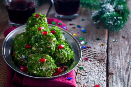 Festive appetizer in the form of balls of salted herring in fresh dill, selective focusの写真素材