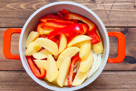 Step by step cooking of khashlama with beef and vegetables, step 4 - adding chopped pepper and potatoes, top viewの写真素材