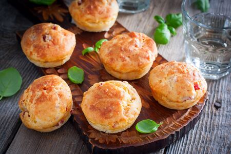 Muffins with ham and cheese on a wooden board, selective focusの写真素材