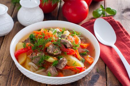 Khashlama with beef and vegetables on a wooden table, selective focusの写真素材