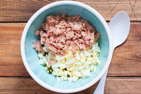 Step by step preparation of salad with canned tuna and corn, step 5 - adding canned tuna fillet to the salad, top view, horizontalの写真素材