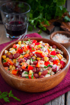 salad with red beans, corn and bell peppers in a wooden salad bowl, selective focusの写真素材