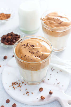 Cold Dalgon coffee in a glass on a white background. A trendy drink made from whipped instant coffee and milk. Close up.の写真素材