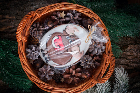 Christmas basket with cones, tree decorations and gingerbread in the form of a bull in a package,...