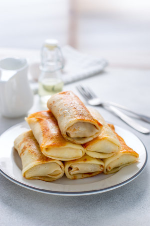 Served breakfast table with stuffed pancakes on a white plate, selective focusの写真素材