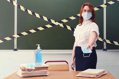 School doctor handing out medical masks in the classroom. Education problems during the coronavirus quarantineの写真素材