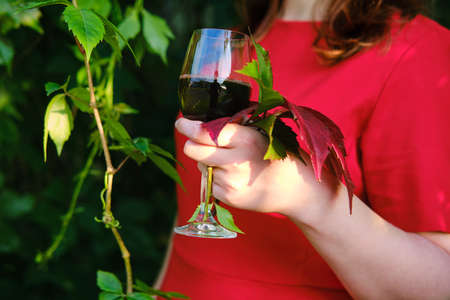 A glass of grape juice in a woman hand, close-upの写真素材