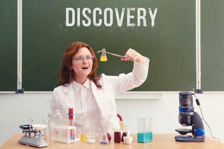 Surprised woman scientist with a flask in her hands made a scientific discovery. Conducting scientific research in the student laboratoryの写真素材