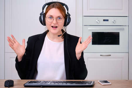 A woman is ecstatic video call at a remote job from home. Businesswoman in a suit and glasses happy, screen monitor online conferenceの写真素材