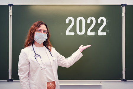 School doctor shows on the blackboard with the inscription 2022