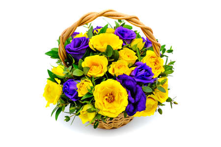 Basket with yellow and blue flowers on isolated white background. Bouquet of yellow and purple roses. Beautiful flowers in a wicker basket. Bouquet of fresh roses in an interesting composition.の写真素材