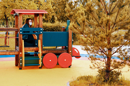 Mom baby sitting in a toy train in the playground