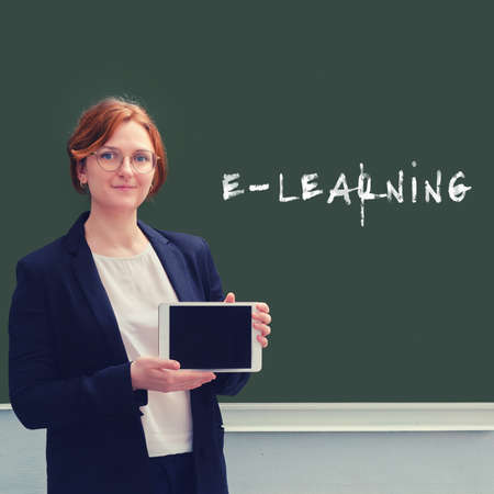 School teacher and the text "e-learning" is written on the blackboard, the concept of distance learningの写真素材