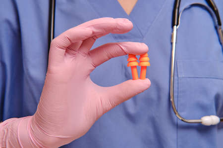 Earplugs in the hands of a doctor in protective medical gloves, close-upの写真素材