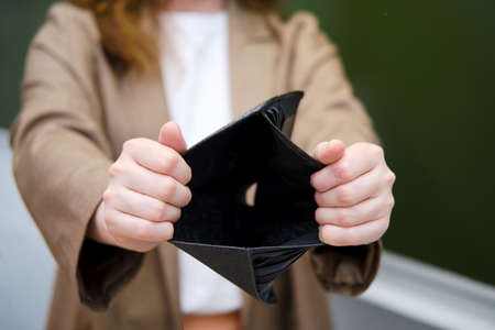 School teacher keeps an empty wallet with no money. Concept of problems at school during the coronavirus epidemicの写真素材