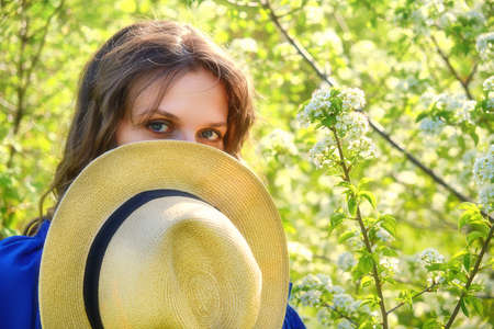 Portrait of a girl covering her face with a straw hatの写真素材