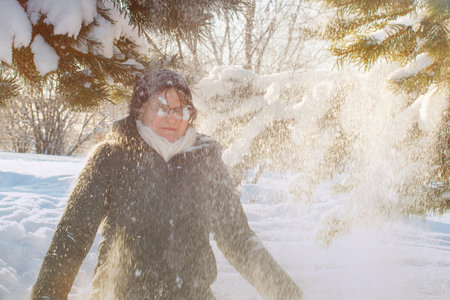 A young woman was covered with snow from a tree branch