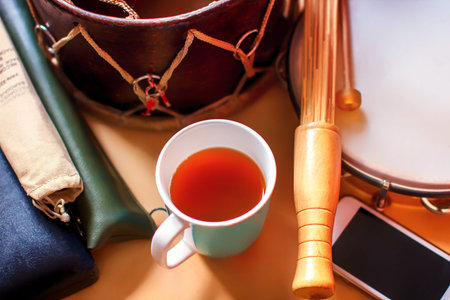 Composition of ethnic musical instruments, telephone and a Cup of tea. Drum, cases with flutes and...
