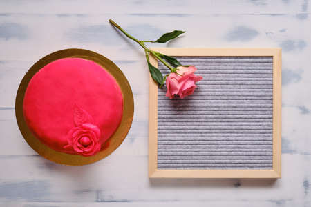 Red cake covered with marzepan or mastic with a flower on a white background.の写真素材