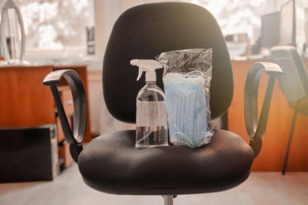 Face masks and sanitizer for disinfection on an office chair, close-up. Working in an office during a coronavirus epidemicの写真素材